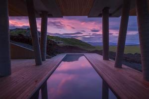 a pool on a wooden deck with a sunset at ION Adventure Hotel, Nesjavellir, a Member of Design Hotels in Nesjavellir
