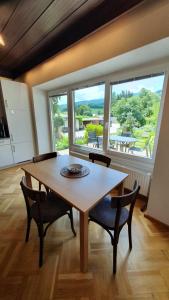einen Tisch und Stühle in einem Zimmer mit einem großen Fenster in der Unterkunft Gasthof Grüner Baum in Kirchberg am Wechsel