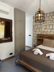 a bedroom with a bed and a stone wall at Argente Alaçatı (Adult Only) in Alacati