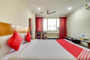 ein Hotelzimmer mit einem großen Bett mit roten Kissen in der Unterkunft OYO Srinivasa Residency in Tirupati