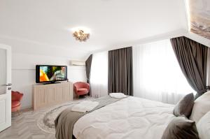 a bedroom with a large bed and a television at VILA REYNA in Galaţi