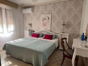 ein Schlafzimmer mit einem Bett mit zwei roten Kissen in der Unterkunft Romantico Wellness Casa Veronica in Elche