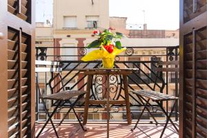 uma mesa com um vaso de flores numa varanda em Bright Apartment with Balconies em Barcelona