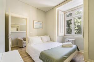 um pequeno quarto com uma cama e uma janela em Metropolitan Living Lisbon - Janelas Verdes em Lisboa