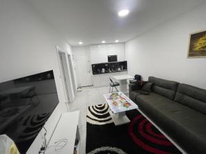 ein Wohnzimmer mit einem Sofa und einem Tisch in der Unterkunft Apartmani K&V in Veliko Gradište