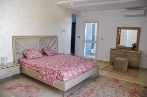 a bedroom with a bed and a dresser and a mirror at MAISON RITEl 1 in Taguermess