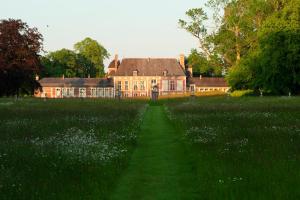 a house in the middle of a field of flowers at Le château de Bonnemare - Bed and breakfast in Radepont