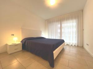 a bedroom with a large bed and a window at Costa Azzurra Apartment in Grado