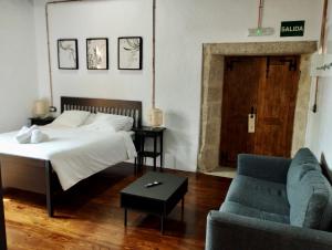 ein Schlafzimmer mit einem Bett, einem Sofa und einem Tisch in der Unterkunft Monasterio y Pensión de Moraime in Muxia