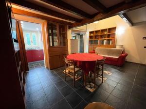 a kitchen with a red table and chairs in a room at Musicians Mansion Loft in Fino Mornasco