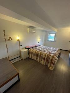 een slaapkamer met een bed en een houten vloer bij Loft con tutti i comfort! in Fino Mornasco