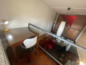 een kamer met een bureau, een stoel en een lamp bij Loft con tutti i comfort! in Fino Mornasco