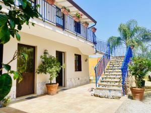 une maison avec des escaliers bleus et une porte dans l'établissement Borgo Camicia In, à Barcellona-Pozzo di Gotto
