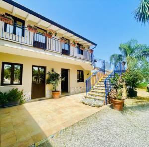 a house with a blue staircase in front of it at Borgo Camicia In in Barcellona-Pozzo di Gotto