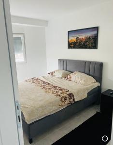 un letto in una camera da letto con una foto sul muro di Apartmani K&V a Veliko Gradište