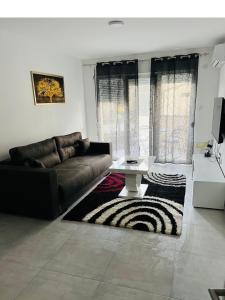 - un salon avec un canapé et une table dans l'établissement Apartmani K&V, à Veliko Gradište
