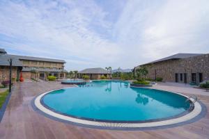 a large blue swimming pool in front of a building at Pushkara Resort and Spa, Pushkar in Pushkar