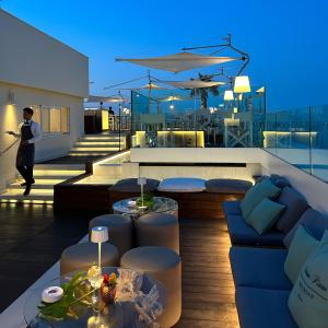 a living room with a couch and tables on a roof at Hotel Lungomare in Riccione