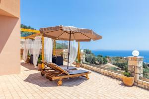 une terrasse avec une chaise et un parasol et l'océan dans l'établissement Nami Villa _PrivatePool_ SeaView, à Palaiokastro