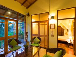 una sala de estar con una habitación con una cama y sillas en Villa Rosa en Kandy