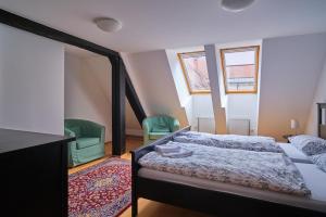 a bedroom with a bed and two green chairs at Samostan Mekinje in Kamnik