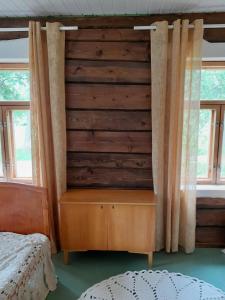 1 dormitorio con pared de madera y vestidor en Cozy cottage by the lake, en Lohja
