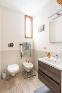 ein weißes Bad mit einem WC und einem Waschbecken in der Unterkunft B&B La Capresina in Sorrent