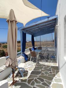 a patio with a table and chairs under a canopy at Villa Lena in Kastraki Naxou