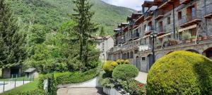 a street in a town with bushes and buildings at El Estudio de Buenavista in Biescas