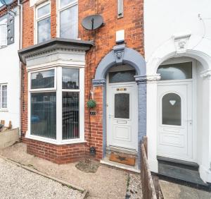 a brick building with a white door and windows at 3 bedroom Shalom Sleeps 5 - Ideally Located in Hull- 2 Mins walk to Vibrant Newland Ave in Hull