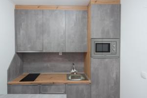 a kitchen with a sink and a microwave at Apartmani PARDON in Pag