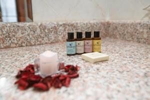 a bathroom counter with three bottles of soap and red roses at Stay Inn Hotel Ain Sokhna in Ain Sokhna