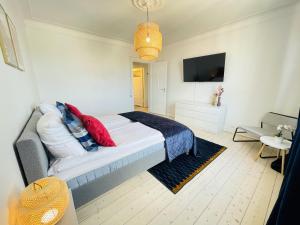 Un dormitorio con una cama con almohadas rojas. en aday - Ocean Shores central Apartment, en Frederikshavn