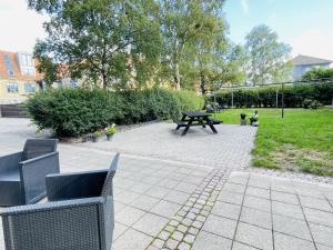 una mesa de picnic y bancos en un parque en aday - Ocean Shores central Apartment, en Frederikshavn