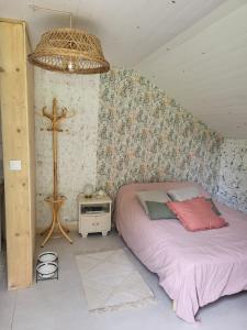 a bedroom with a bed and a cross on the wall at La Kabane in Fierville-les-Mines
