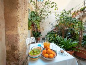 einen Tisch mit einer Schale Orangen und Obst darauf in der Unterkunft Confortevole Open Space [Centro Storico] in Marsala