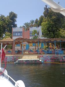 a boat in the water in front of a building at Awi Guest House in Aswan