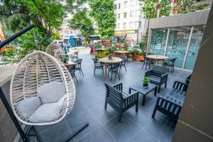 eine Außenterrasse mit Stühlen, Tischen und Hängematten in der Unterkunft The Gate Kadıköy Downtown in Istanbul