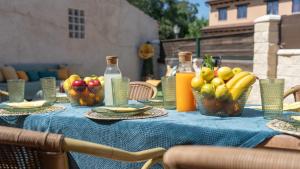 a table with bowls of fruit and bottles of juice at La Casita de Lucia in Trescasas