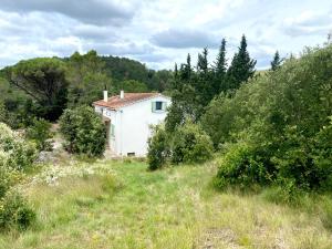 a small white house in the middle of a field at Zen Experience including Yoga & Healthy food in Ladern-sur-Lauquet