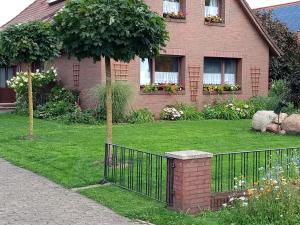 a house with a fence in front of a yard at Ferienwohnung Rühlmann in Detern
