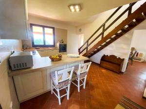 uma cozinha com um balcão com duas cadeiras e uma escada em B&B Peonia Sun light em Capo Sperone