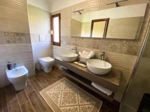 uma casa de banho com 2 lavatórios e 2 WC em B&B Peonia Sun light em Capo Sperone