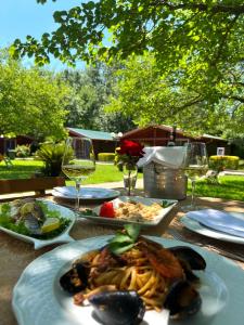 - une table avec des assiettes de nourriture et des verres de vin dans l'établissement Kompleksi Turistik Leonardo, à Shëngjin