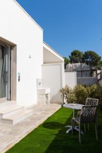 a white house with a table and chairs on a lawn at Cinque Venti BB Porto Cesareo in Porto Cesareo