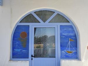 a door with a window with a sailboat painted on it at Villa Lena in Kastraki