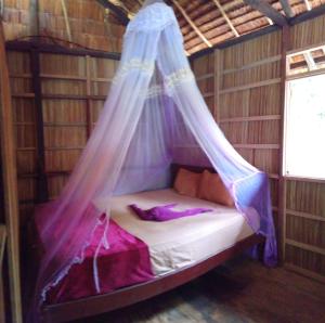 Cama en habitación con mosquitera en Yenrou Homestay, en Yennanas Besir