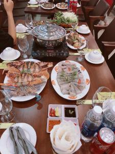 einem Holztisch mit Teller mit Lebensmitteln darauf in der Unterkunft Phương Thuỷ Hotel in Sầm Sơn