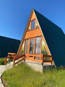 Hotel Skiatori 2 في Kukës: منزل خشبي صغير مع سقف أخضر