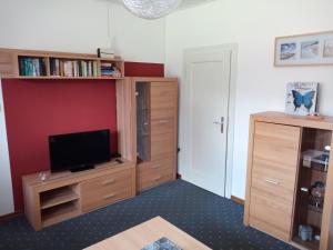 a living room with a tv and a book shelf at Ferienwohnung Rühlmann in Detern